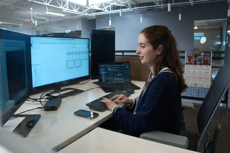 Woman Working at Multi-Monitor Workstation