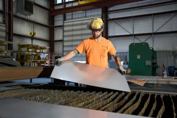 Industrial Worker Placing Metal Sheet