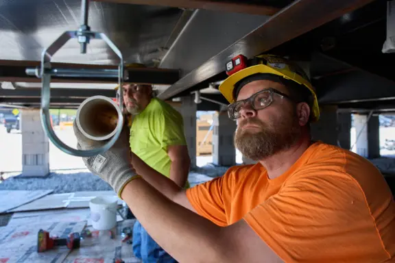 Construction Workers Installing Plumbing