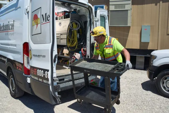 HVAC Technician Unloading Tools from Service Van